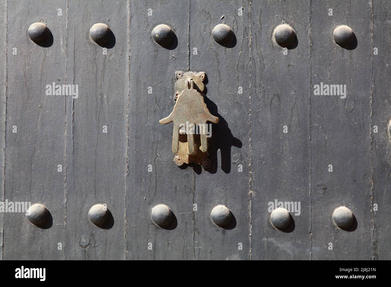 Hamsa, Hand of Fatima door knocker. Traditional Moroccan architecture feature in Marrakech, Morocco. Stock Photo