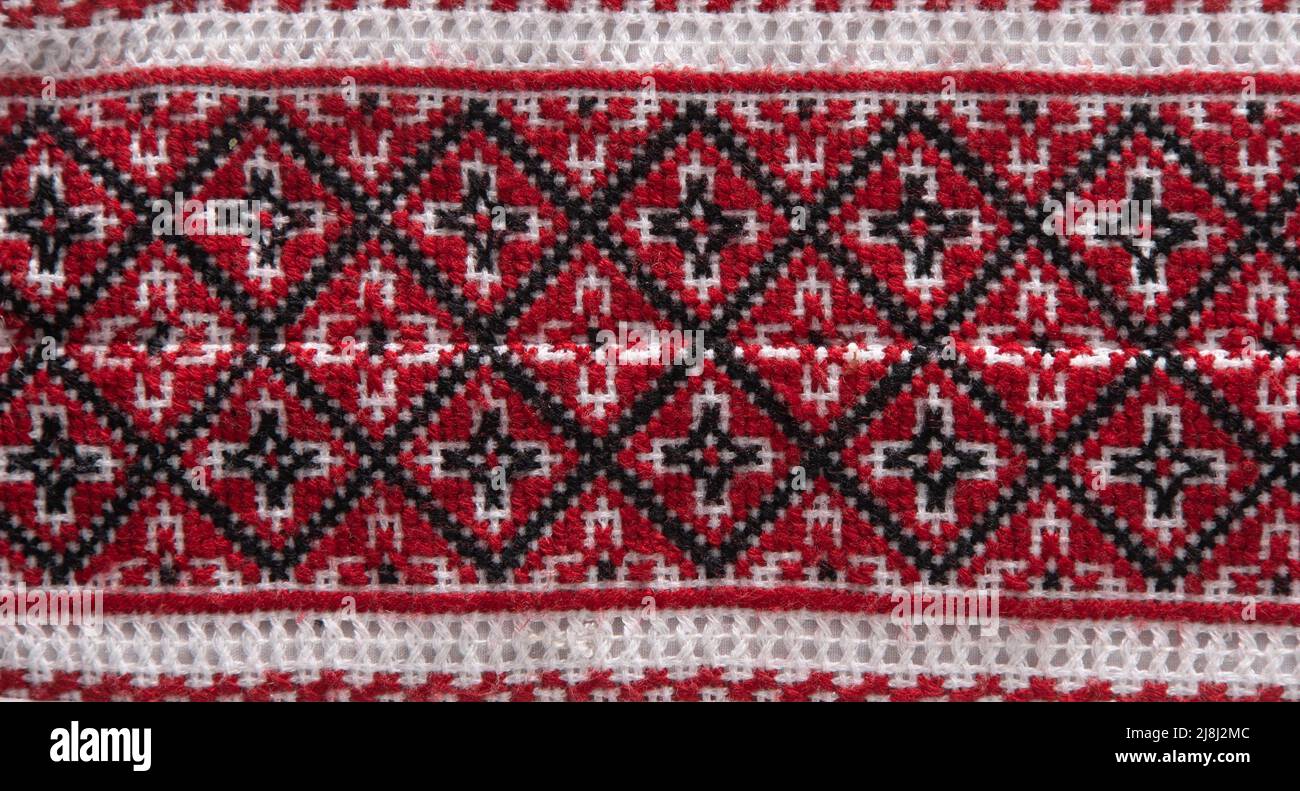National Ukrainian embroidery. Handmade. Cross stitch in red, black and white. Traditional shirt of Ukraine. Embroider background. Stock Photo