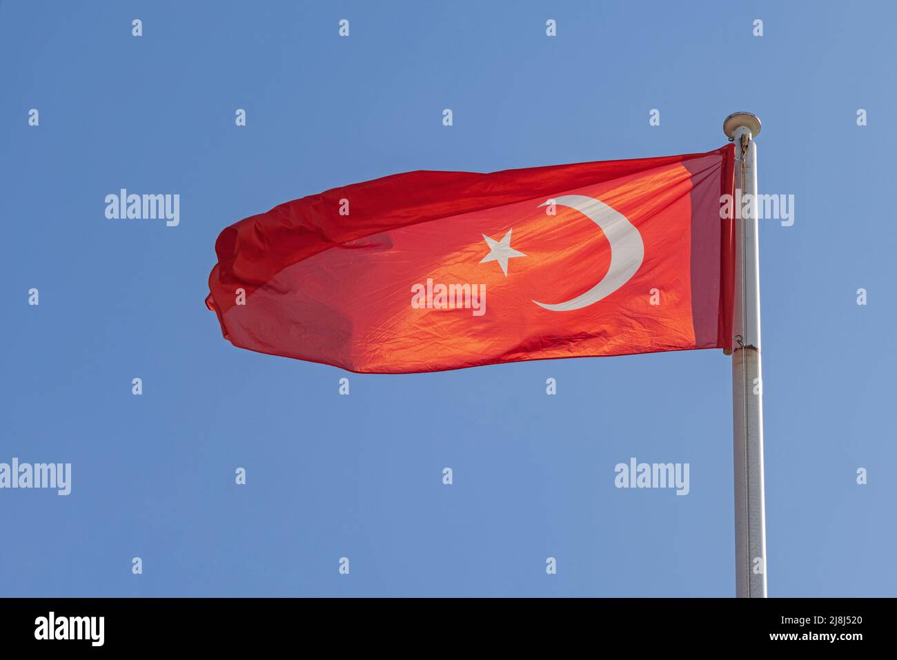 New Bright Red Flag of Turkey at Clear Blue Sky Stock Photo