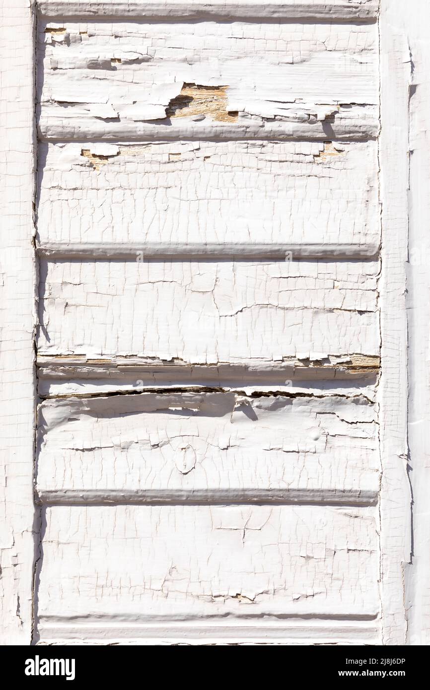 detail of old wooden shutter blind with rotten and cracked white paint Stock Photo