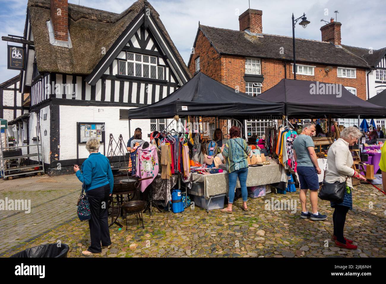 People at the farmers  and makers market around the  cobbled  market square of the Cheshire market town of Sandbach England Stock Photo