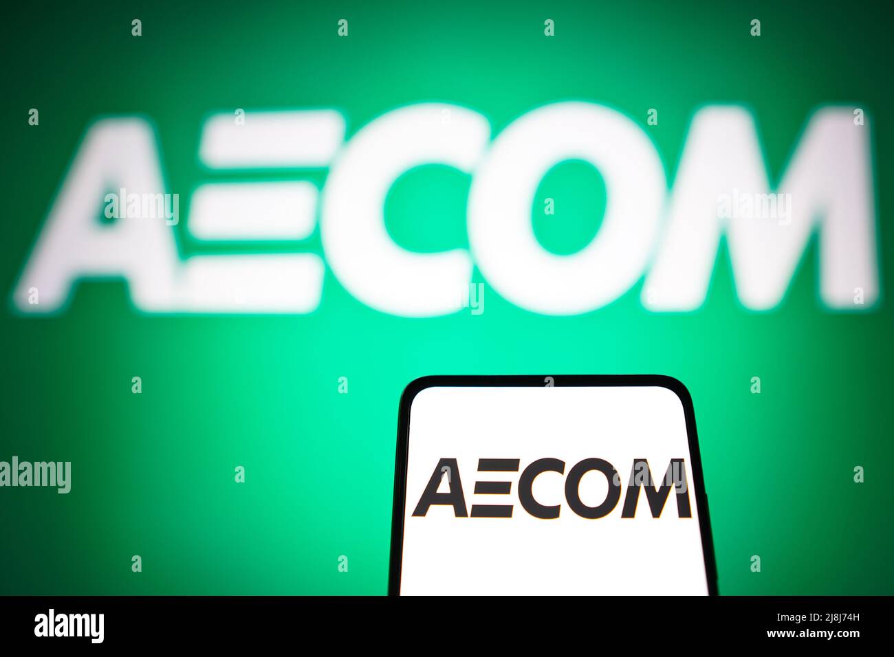 In this photo illustration the AECOM Technology Corporation logo seen displayed on a smartphone and in the background. Stock Photo