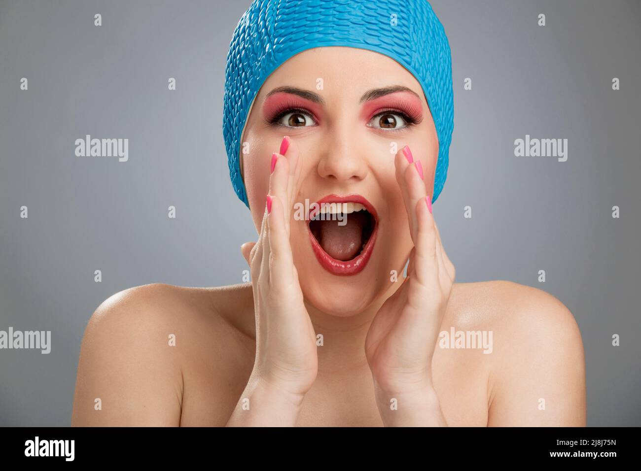 Funny portrait of a beautiful woman wearing a swim cap Stock Photo