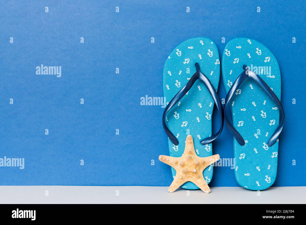 Beach accessories. Flip flops and starfish on colored background. Mock ...