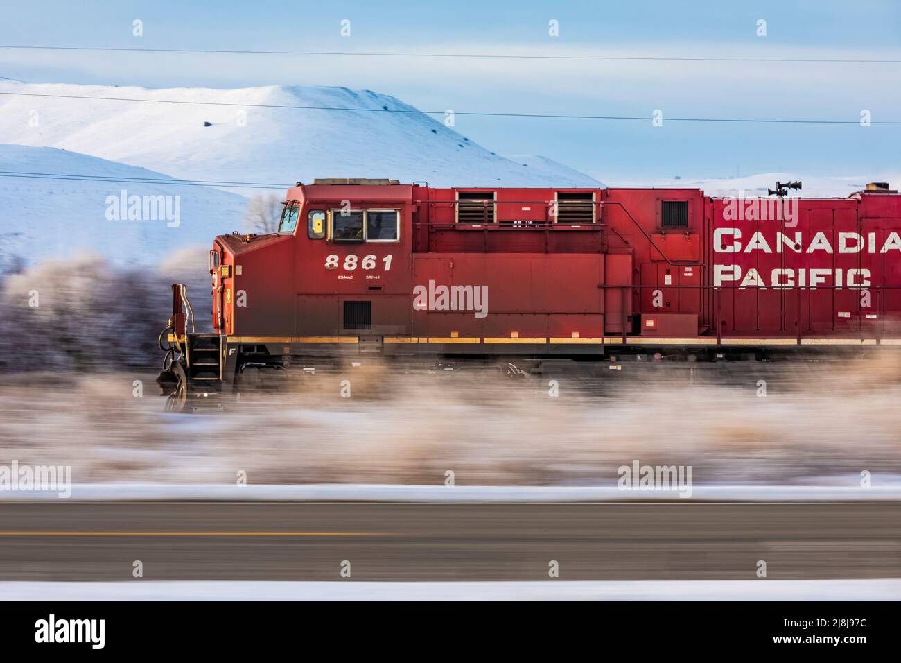 BNSF coal train fronted by a Canadian Pacific locomotive speeding through wintry Montana, USA [No property release; editorial licensing only] Stock Photo