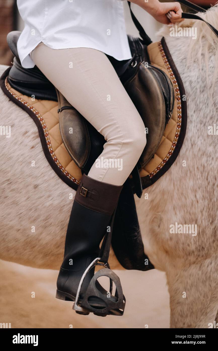 Closeup of a rider's legs in stirrups. A woman on a horse Stock Photo