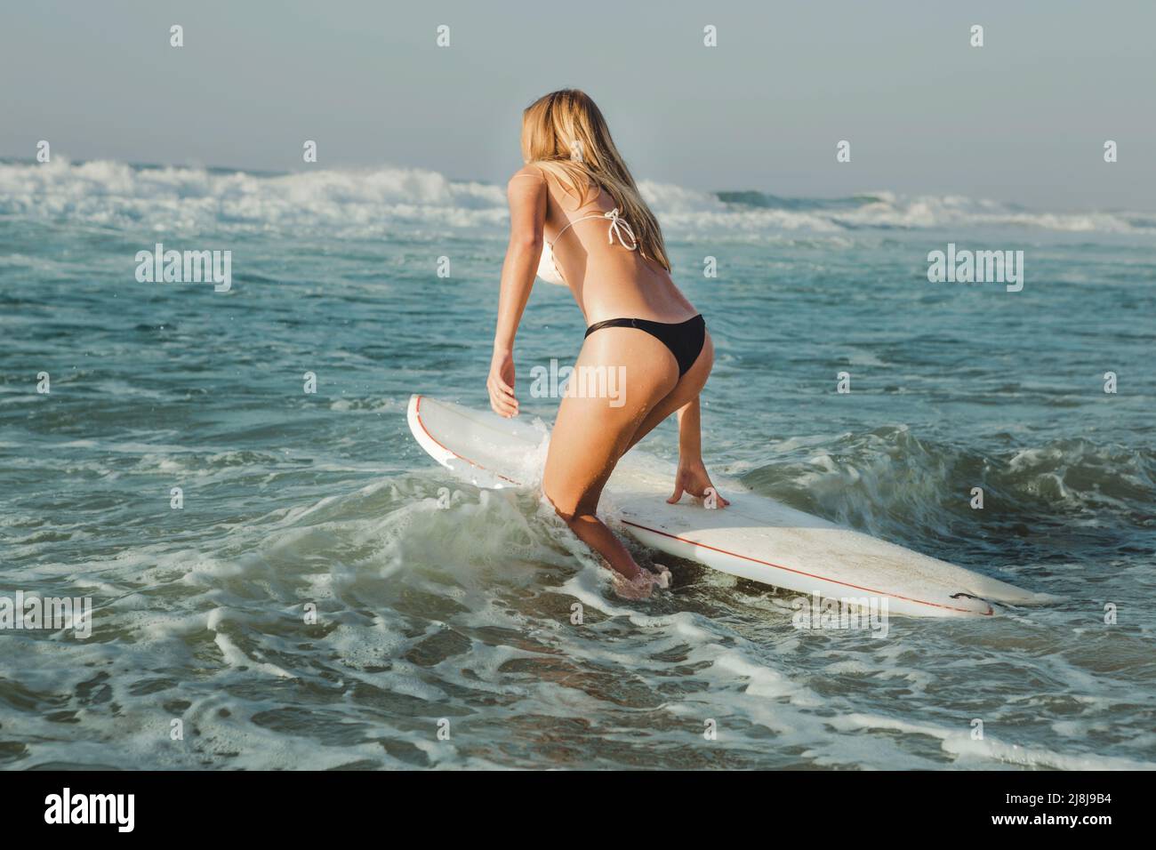 Beautiful woman on the beach going to surf Stock Photo