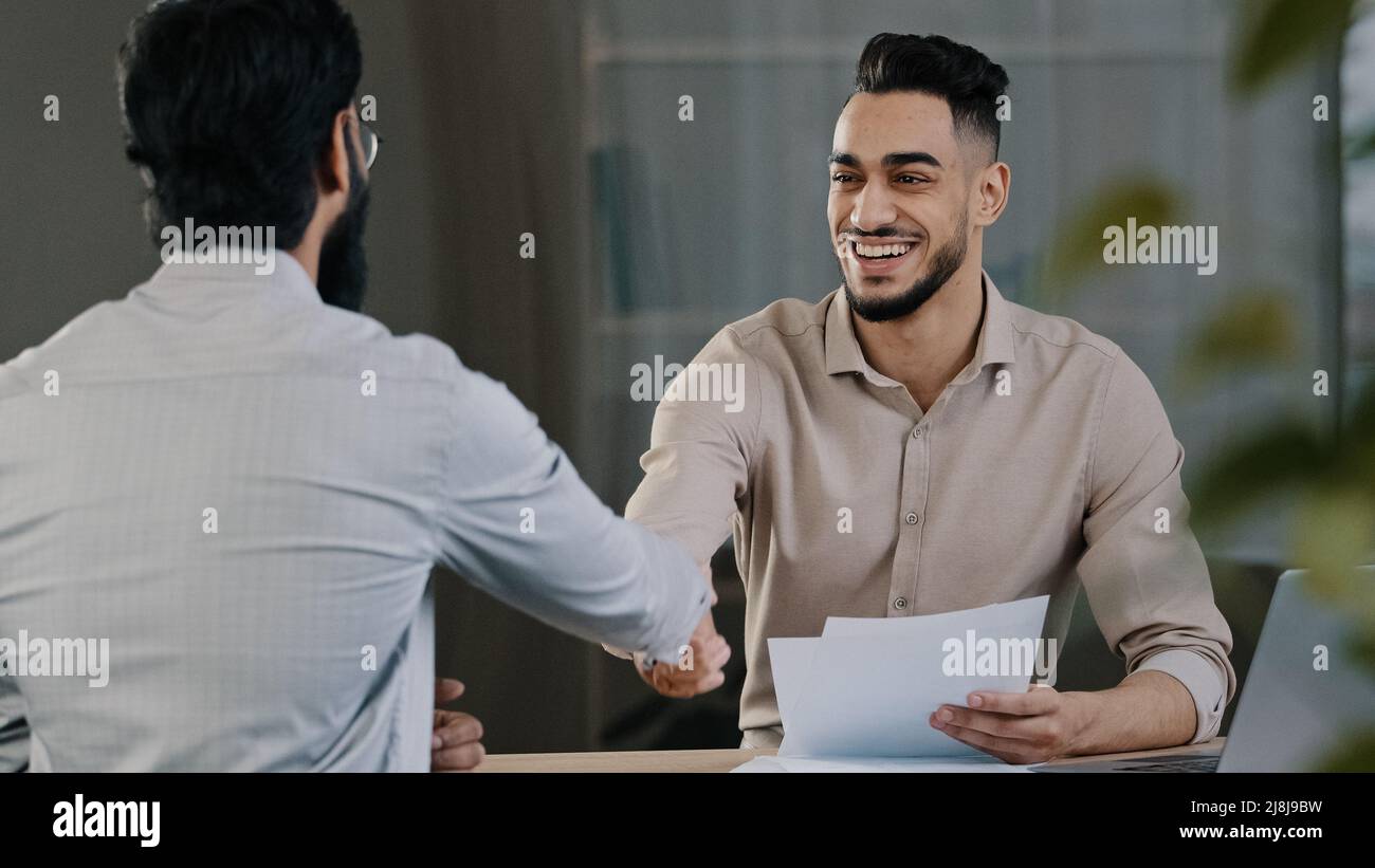 Two successful diverse business men colleague arabian salesman banker male manager shaking hand client customer accept common project successful Stock Photo