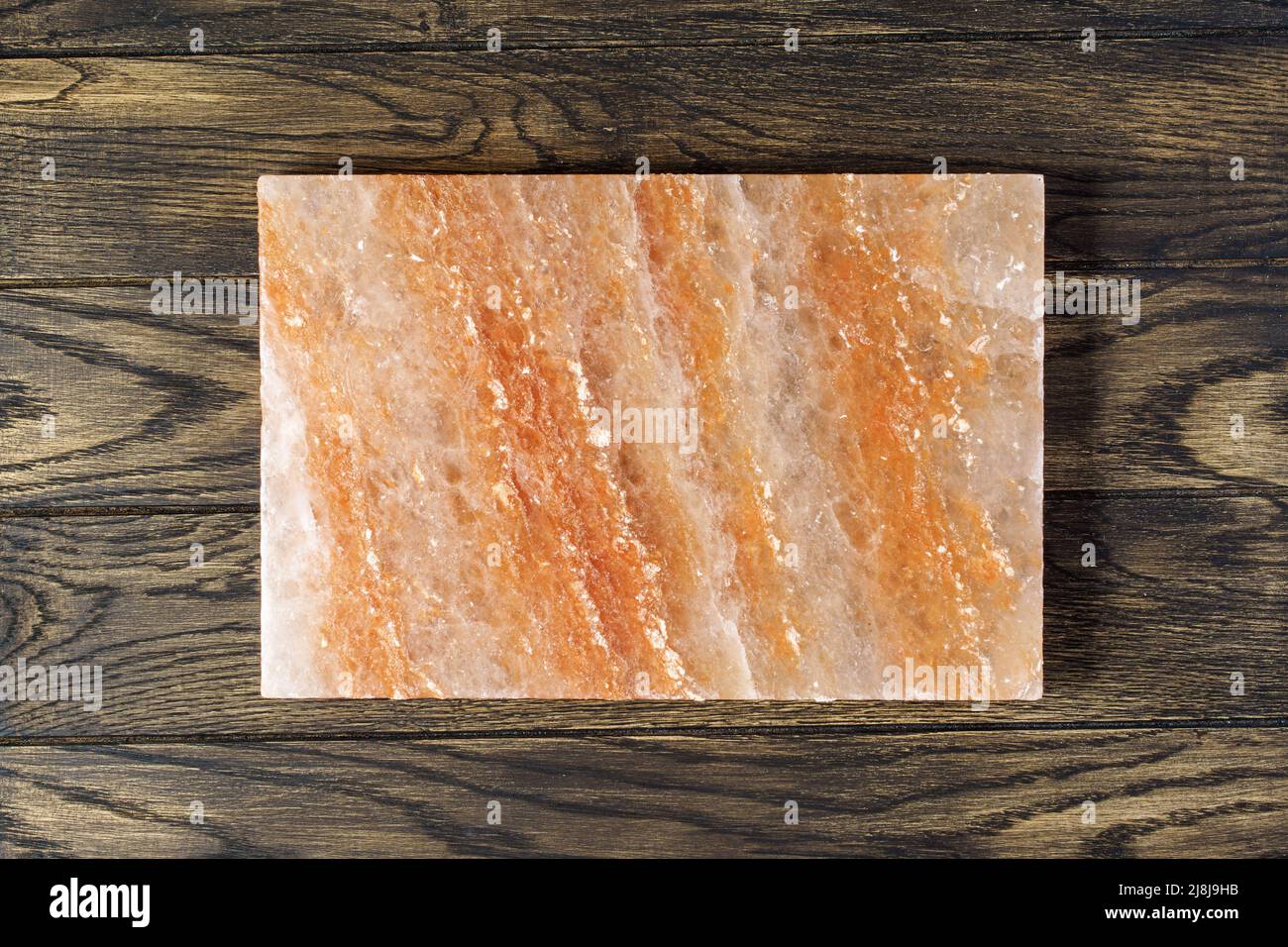 Pink himalayan salt block for cooking and serving the dish on oak