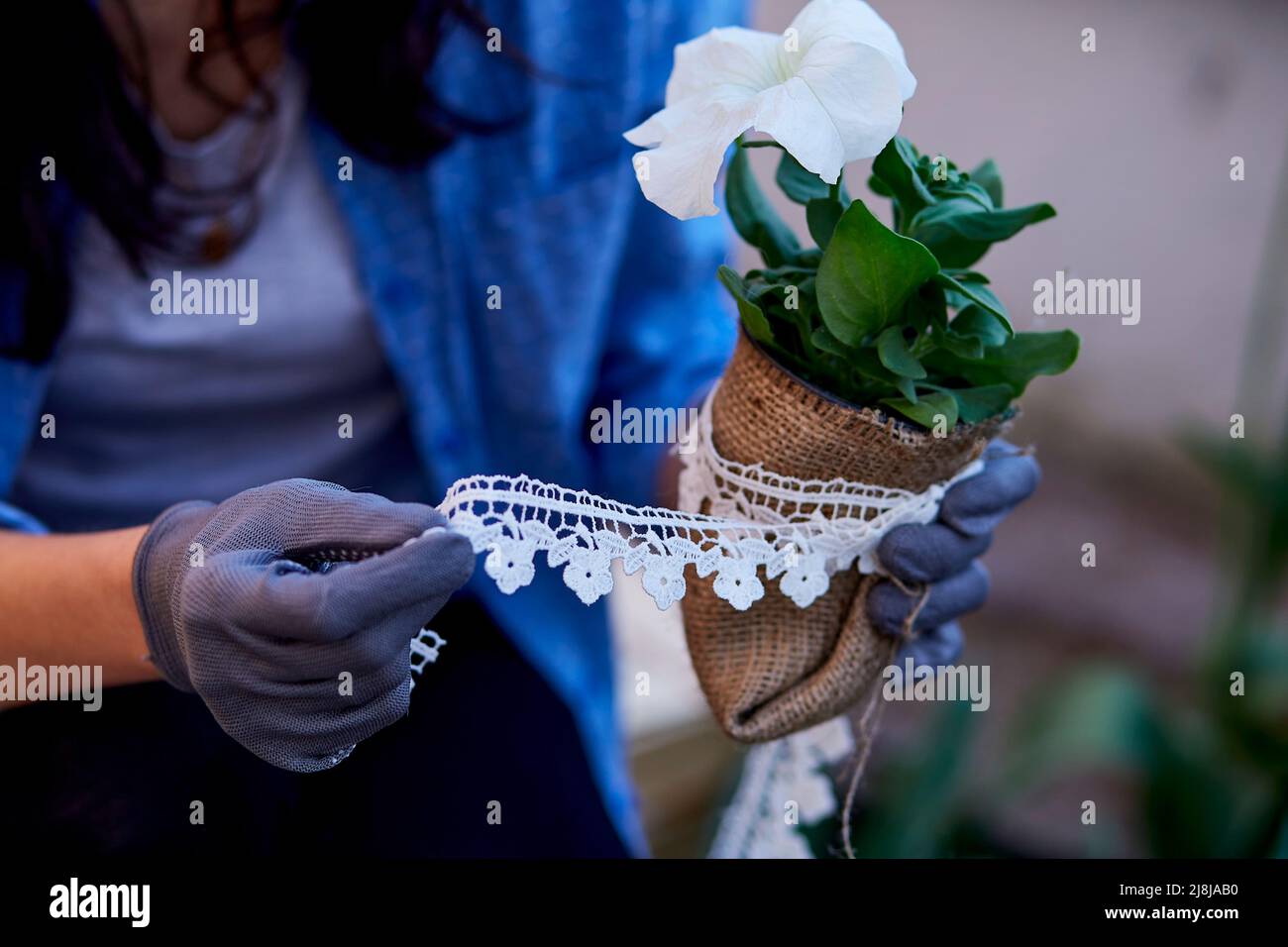 Woman gardener caring and decorating flowers in pots surrounded by plants. Home gardening love