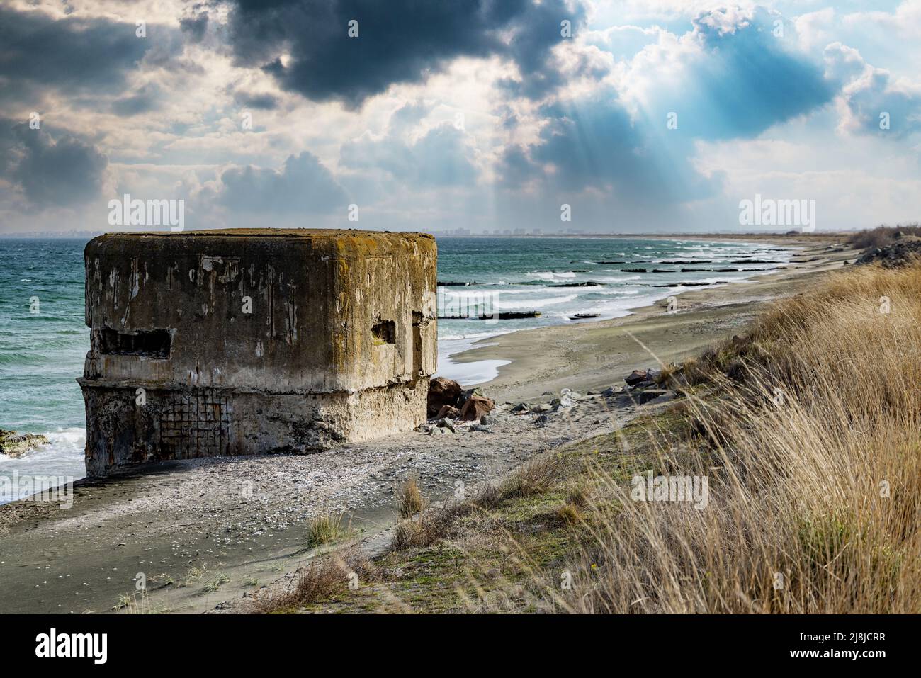 A small concrete abandoned bunker has been standing on a sandy wild ...