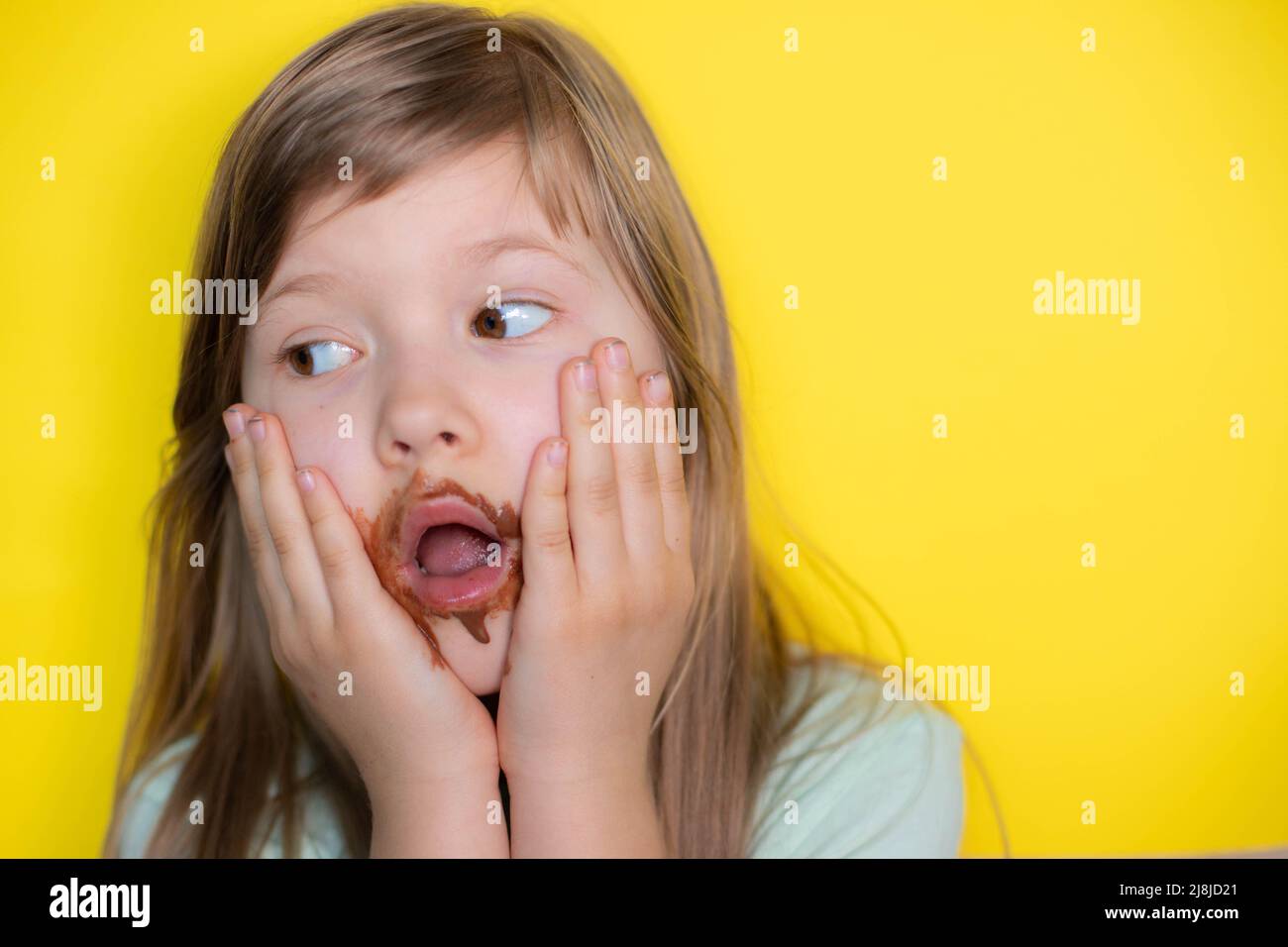 Frightened little girl eating chocolate dirty face Stock Photo
