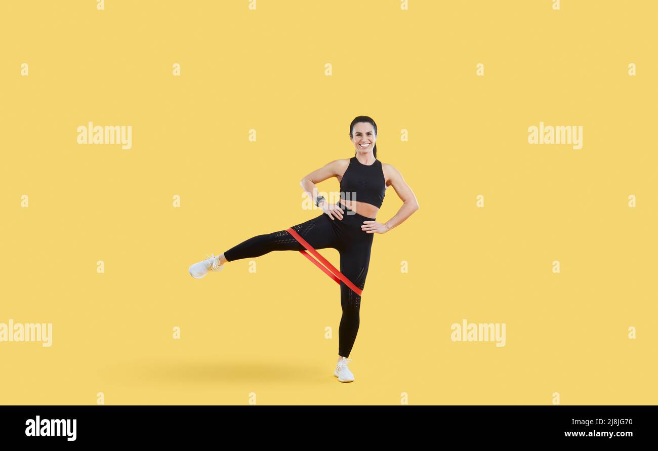 Positive strong sport fitness woman in stylish sportswear trains isolated on beige background. Stock Photo