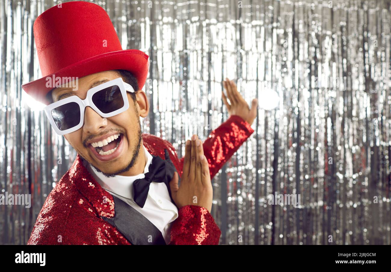 Portrait of cheerful showman, show business artist or host of glamorous show on shiny background. Stock Photo