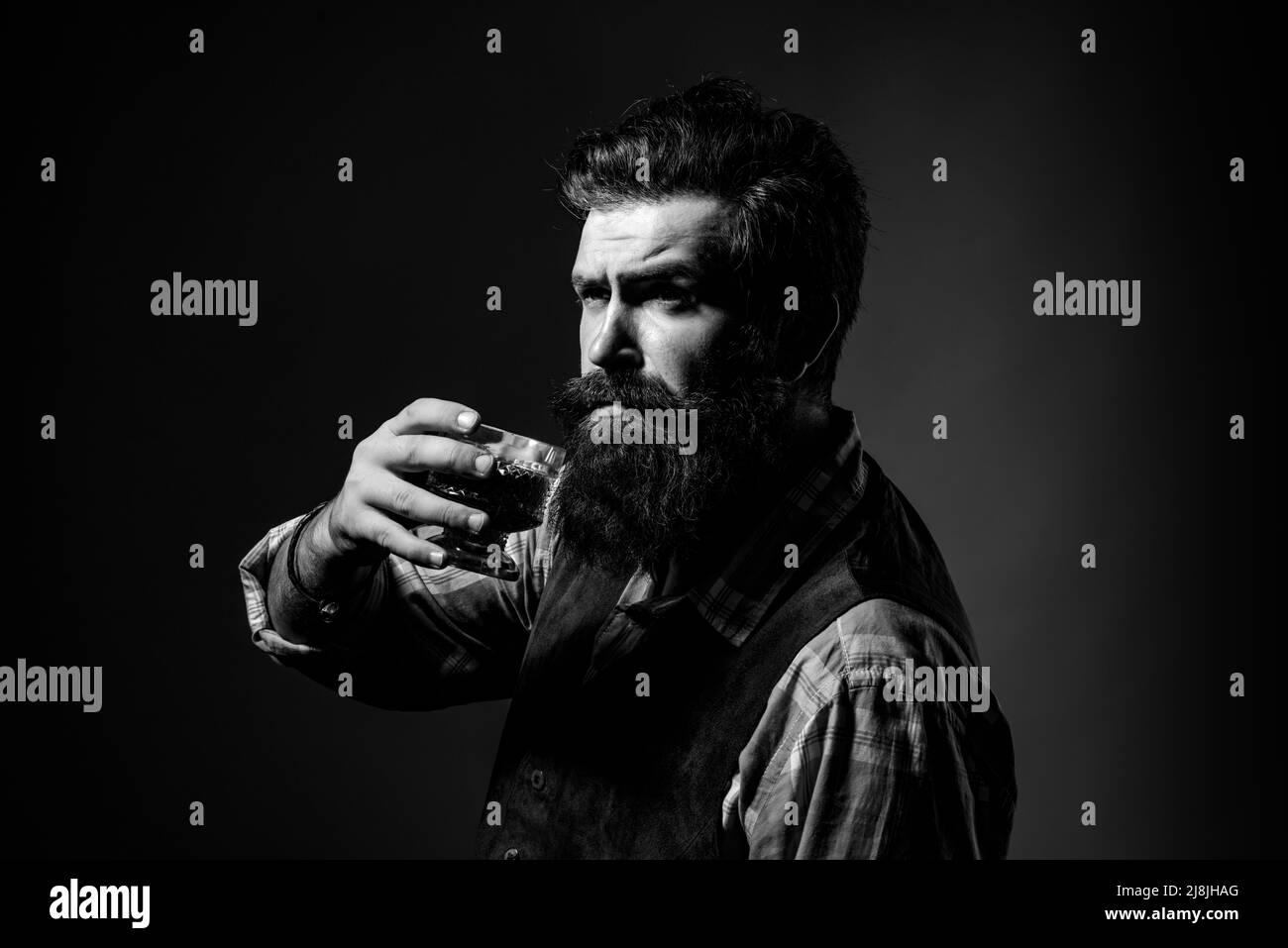 Alcoholic beverage. Man drinking alcohol from glass. Attractive