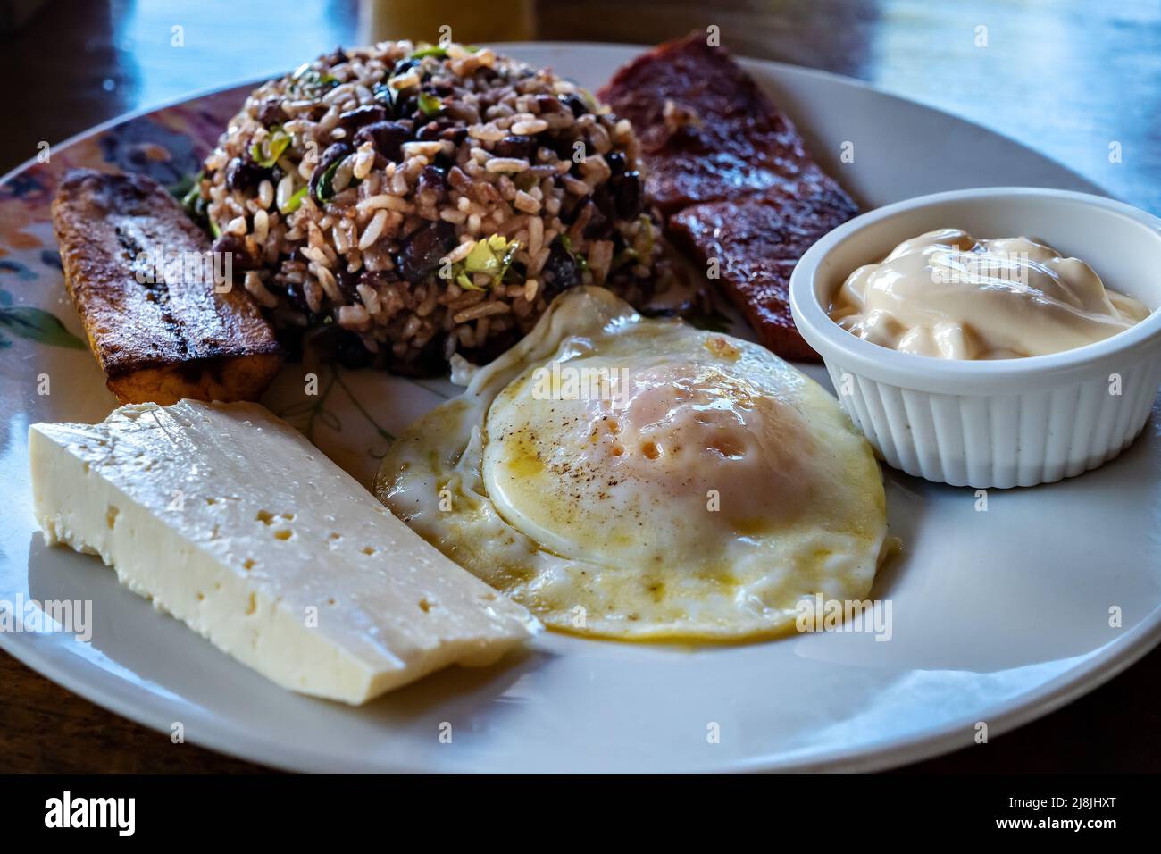Gallopinto (black beans and rice) typical Costa Rican breakfast. Served with eggs, bacon and banana. Stock Photo