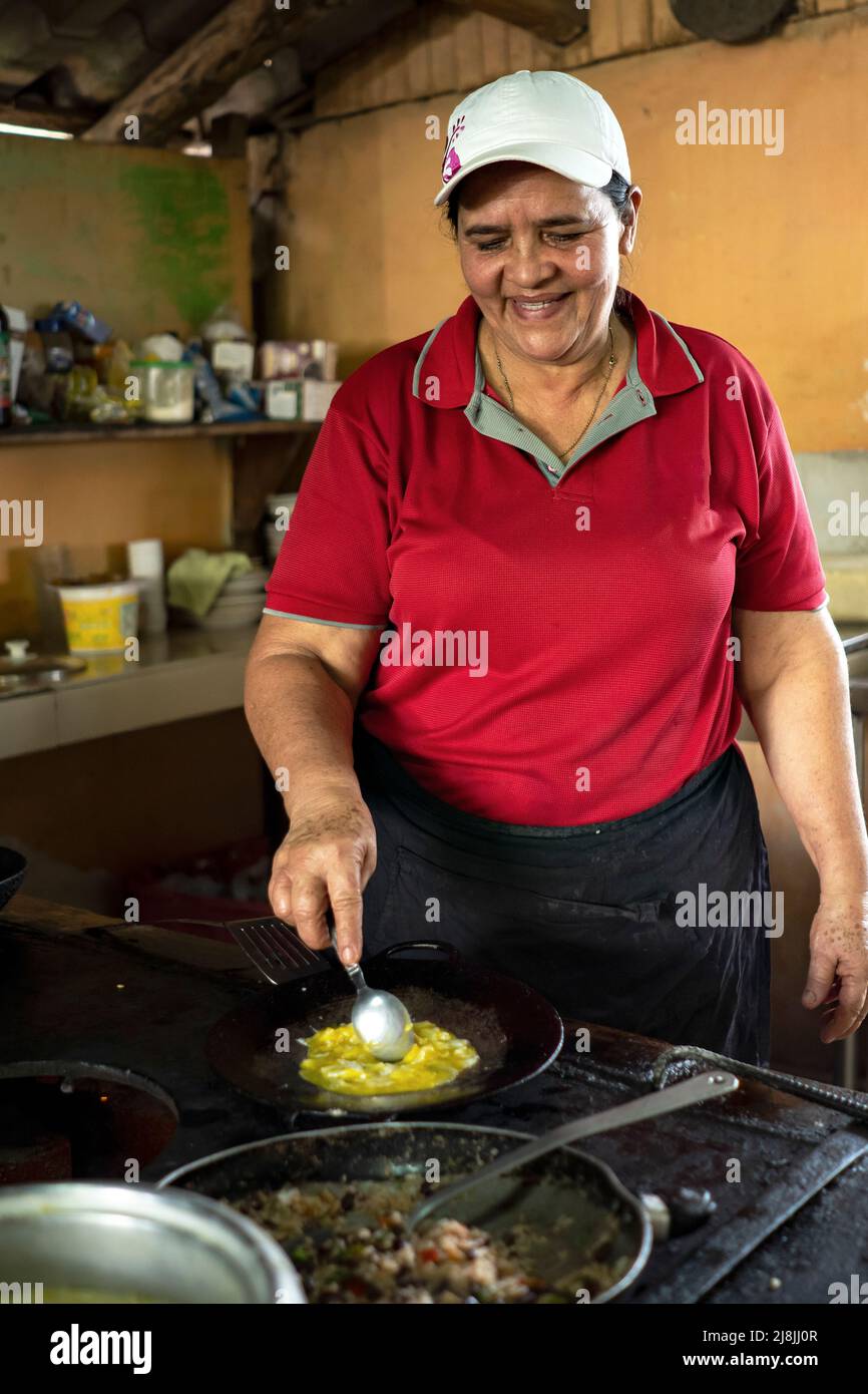Woman cooks traditional Costa Rican lunch of Gallo Pinto, rice and beans and eggs Stock Photo