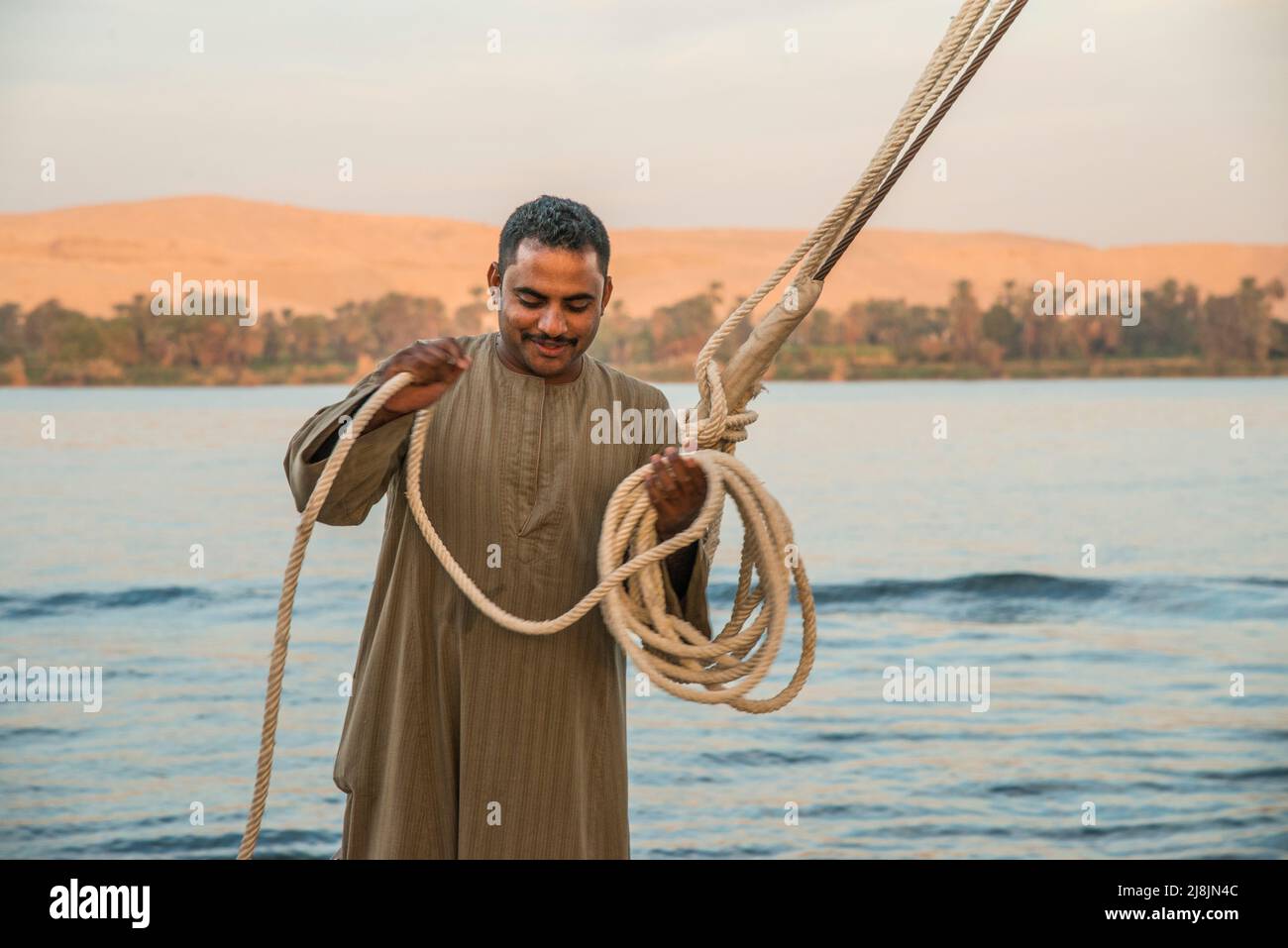 Egpian crew members on a Nile Dhabiay boat fixing the ropes Stock Photo