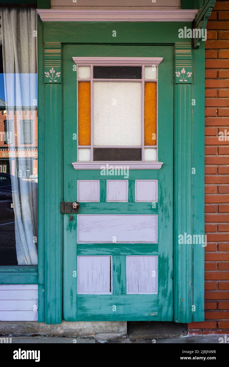 A decorative green, orange and white territorial style door in Deming, New Mexico. Stock Photo