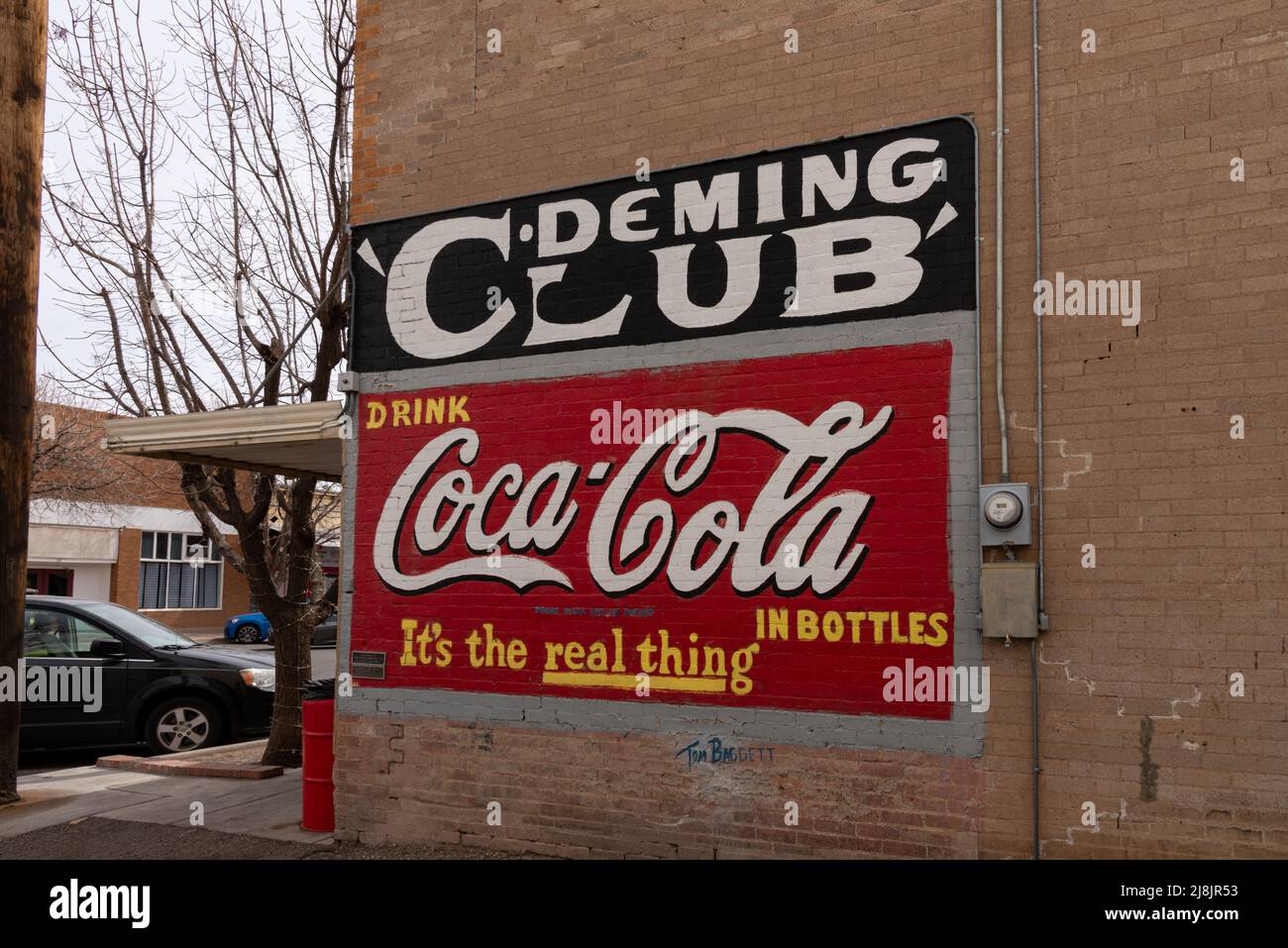 Signs on the side of a building for the Deming Club and Coca Cola that reads Drink Coca Cola in bottles. It's the real thing, Deming, New Mexico. Stock Photo