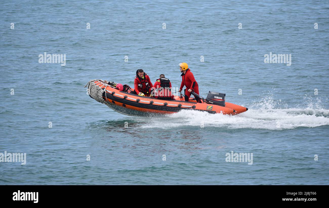 Three lifeguards of the Sécurité Civile (French Civilian Security) sailing in an inflatable boat to rescue people in distress. Stock Photo