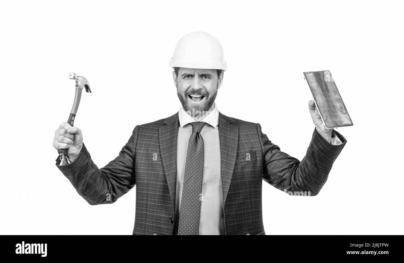 Happy construction man wear safety helmet with formal suit holding hammer and trowel, building Stock Photo