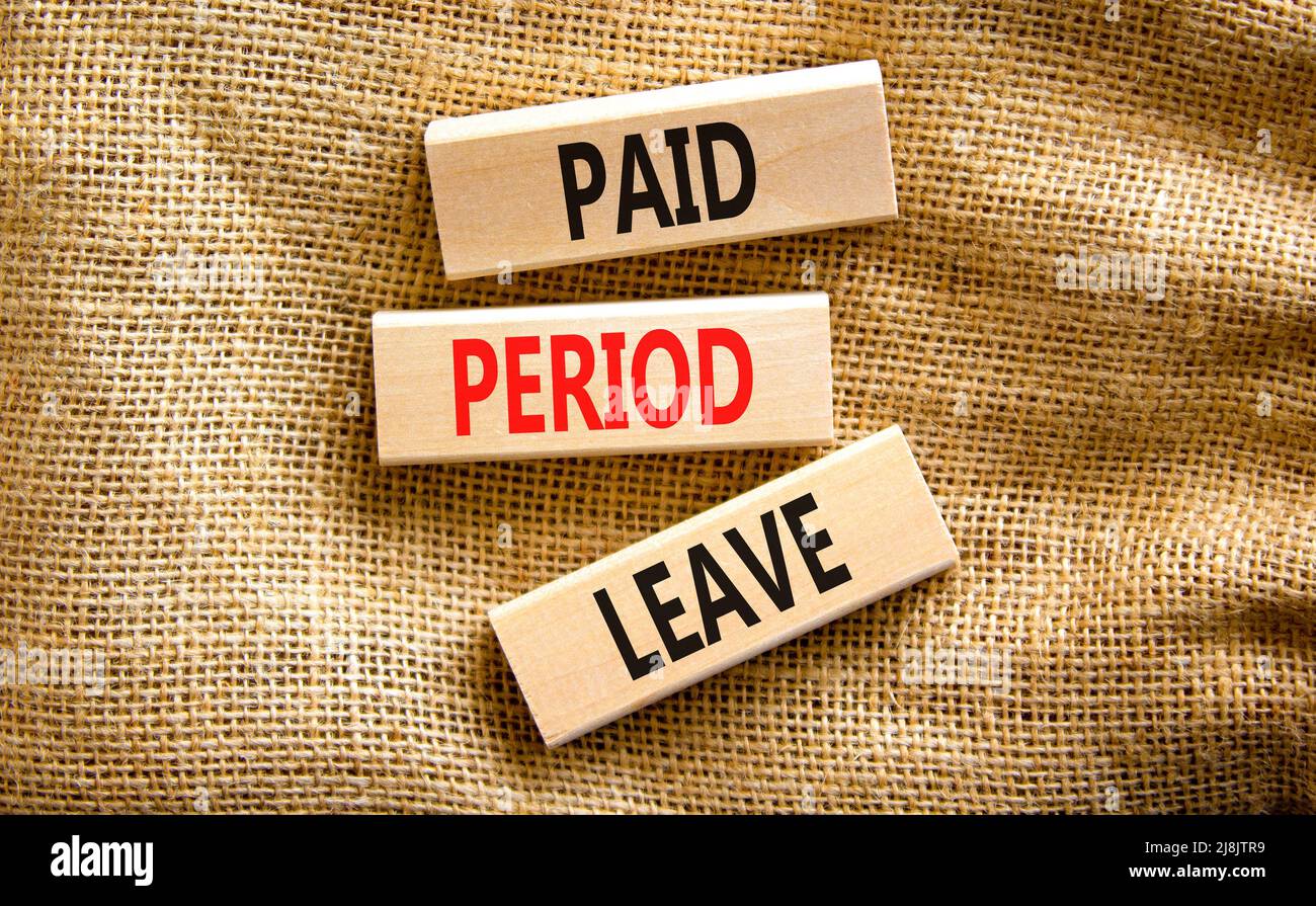 Paid period leave symbol. Concept words Paid period leave on wooden blocks. Beautiful canvas table canvas background. Business medical paid period lea Stock Photo