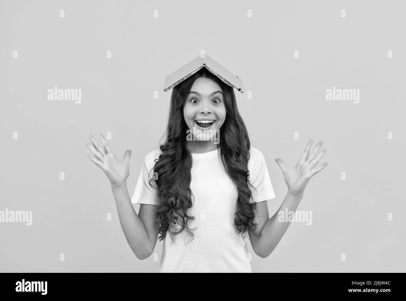 happy school child ready to study with notepad on head, school Stock