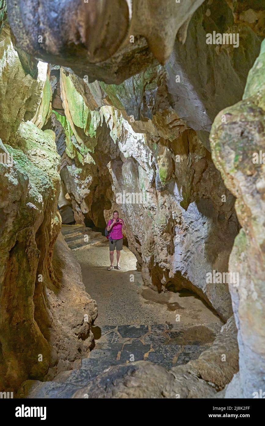 Tourist takes photo at the entrance of the karst cave Cueva del Indio, Cuba, Pinar del Rio, Vinales Stock Photo