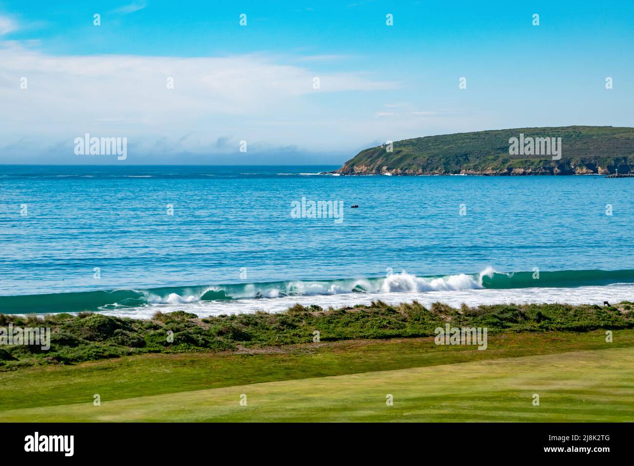 Beautiful blue waves rolling in towards the green fairways of a coastal