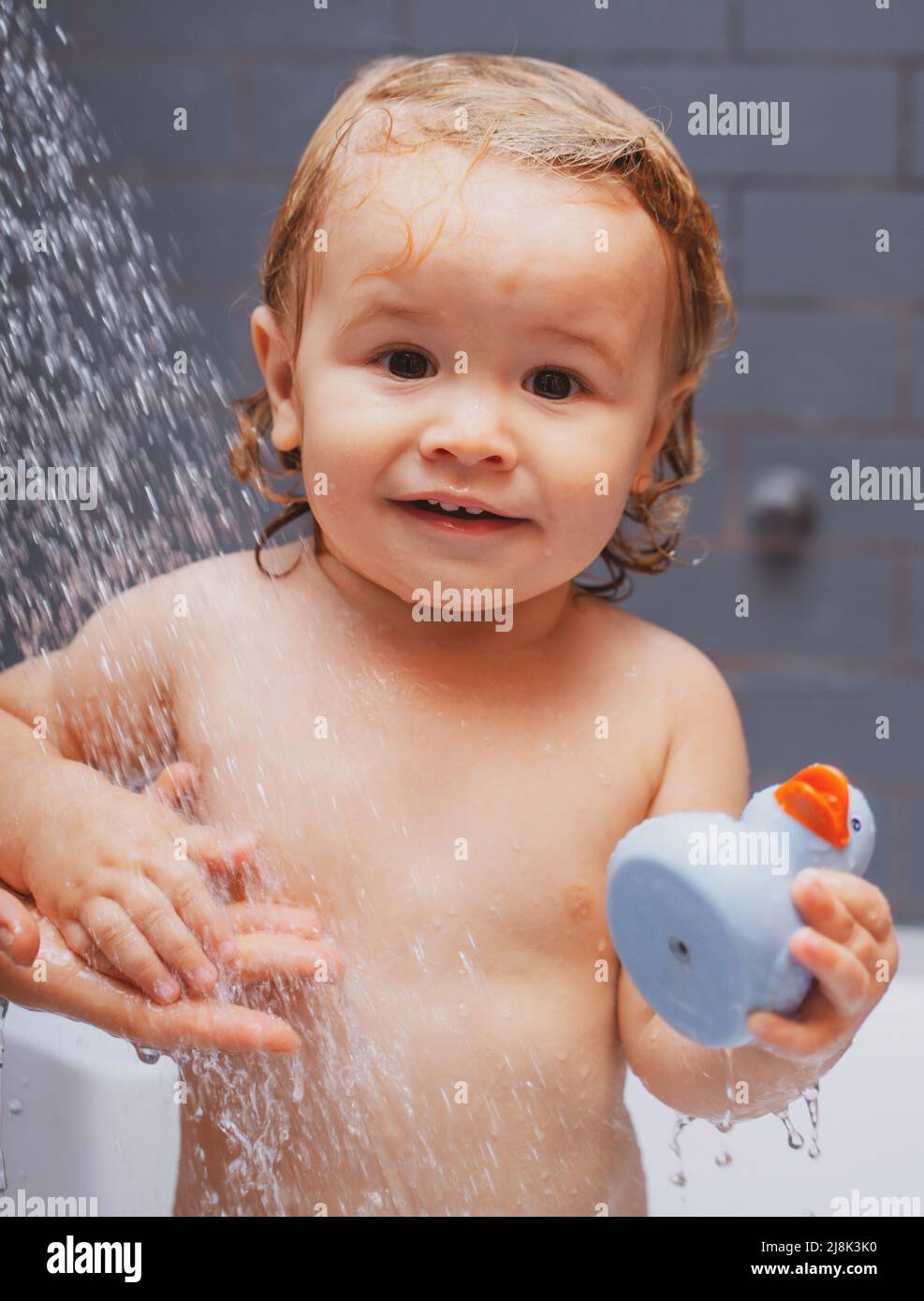 Bathing baby. Happy kid with soap foam on head. Kid shower Stock Photo