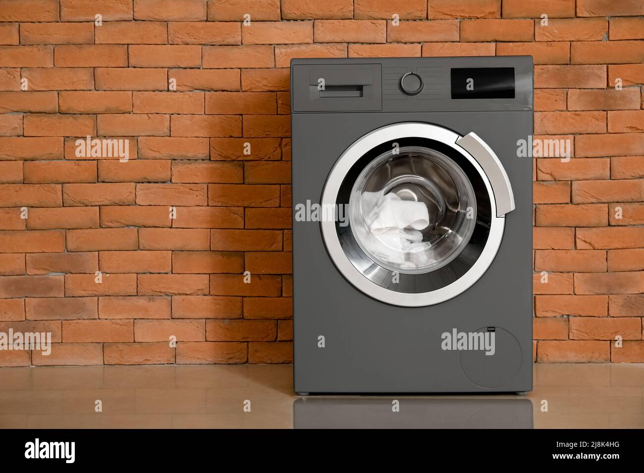 Modern washing machine near brick wall Stock Photo Alamy