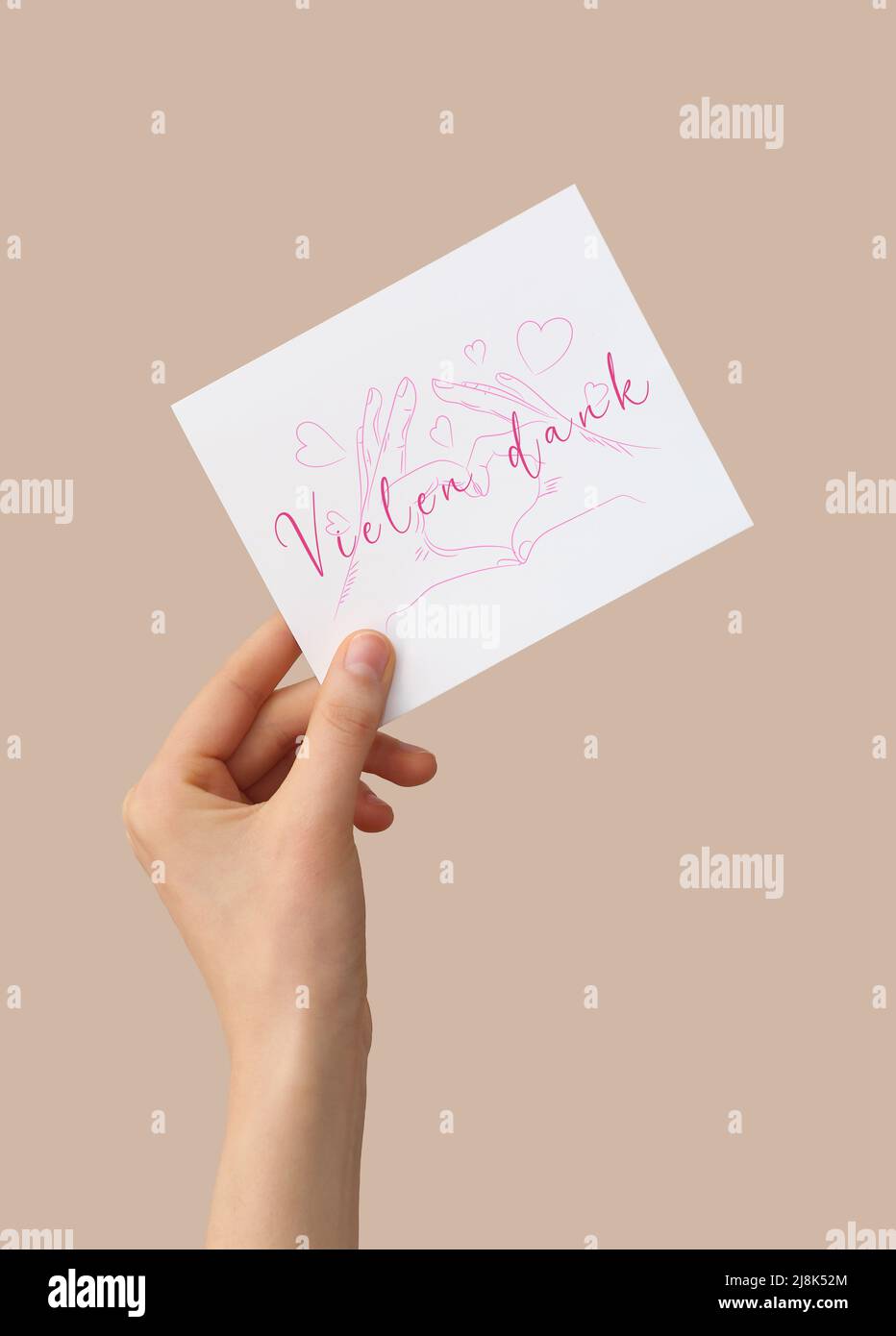 Female hand holding card with text VIELEN DANK (German for Thanks a lot) on color background Stock Photo