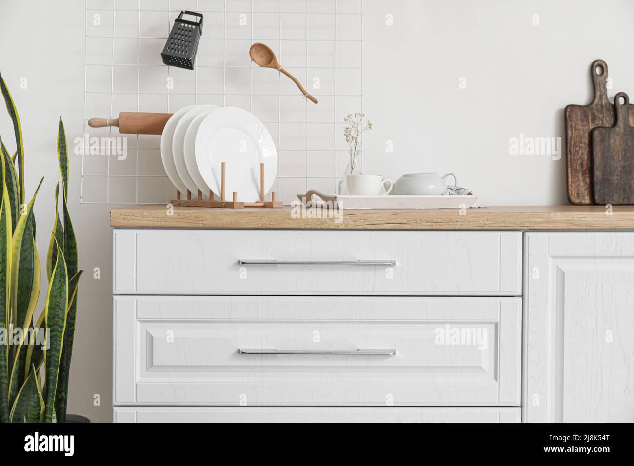 Interior of light kitchen with white drawers and utensils Stock Photo