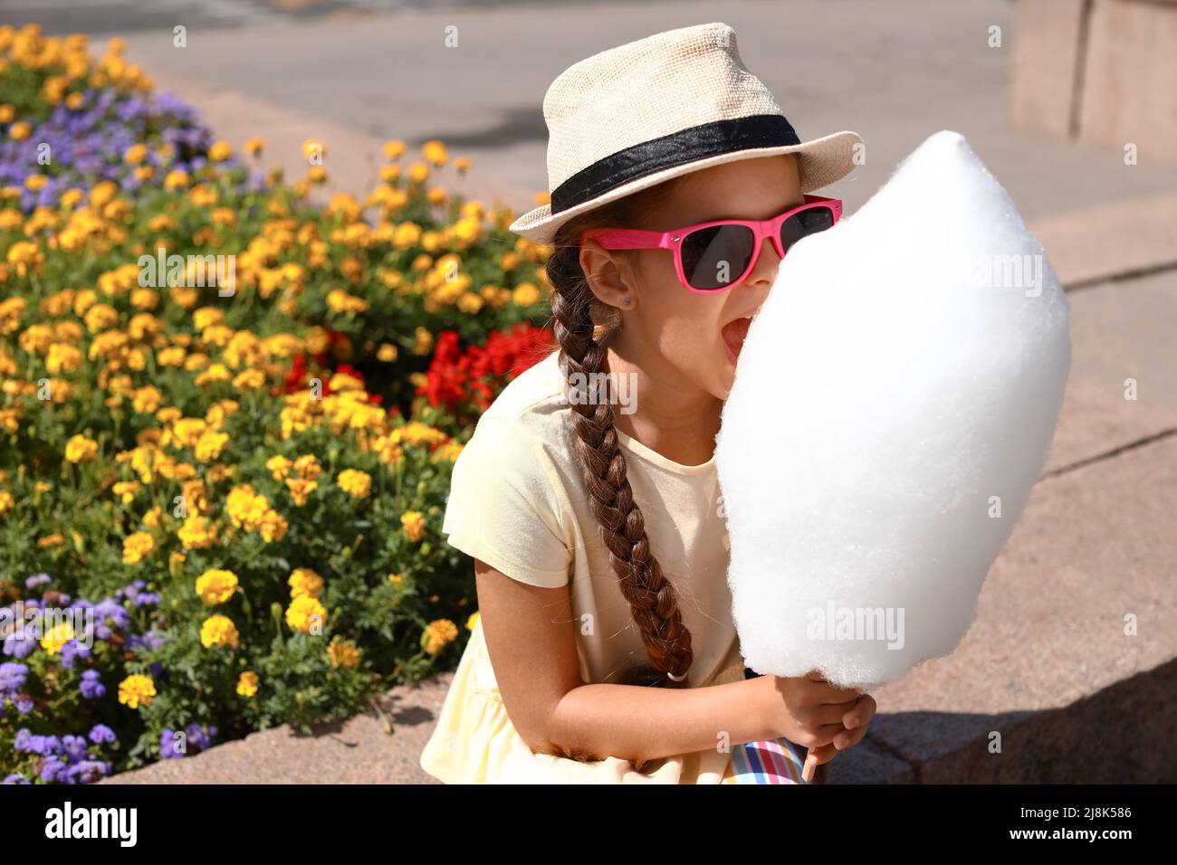 Cute little girl eating cotton candy outdoors Stock Photo Alamy