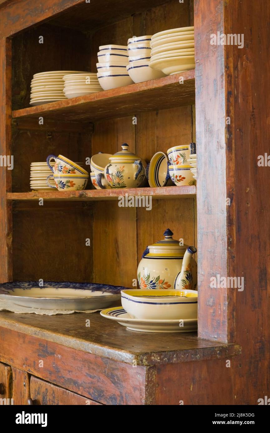 Antique crockery buffet with fine dishes in kitchen inside old circa