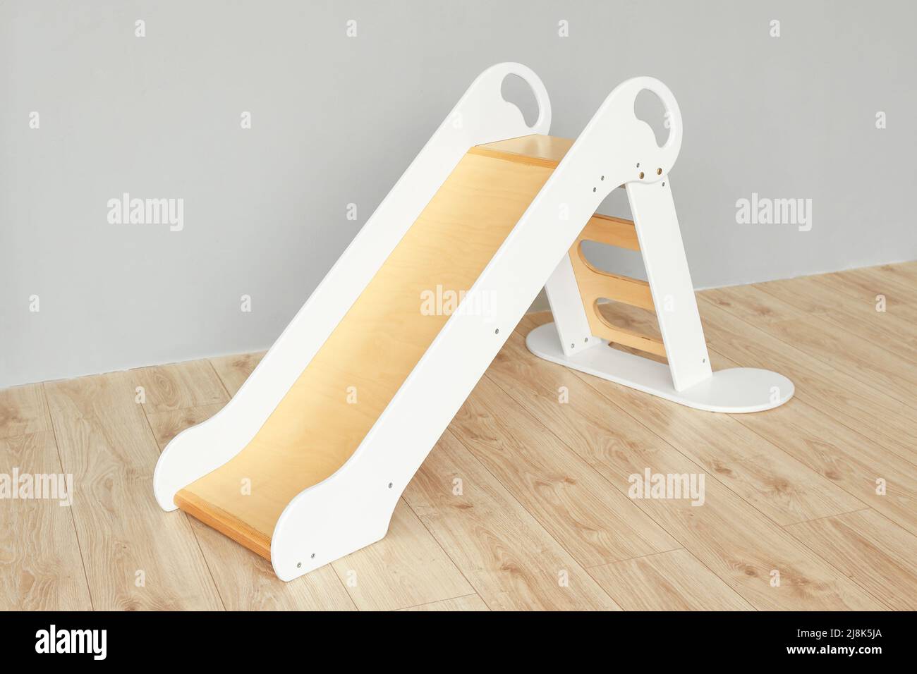 Wooden sliding board near grey wall Stock Photo Alamy