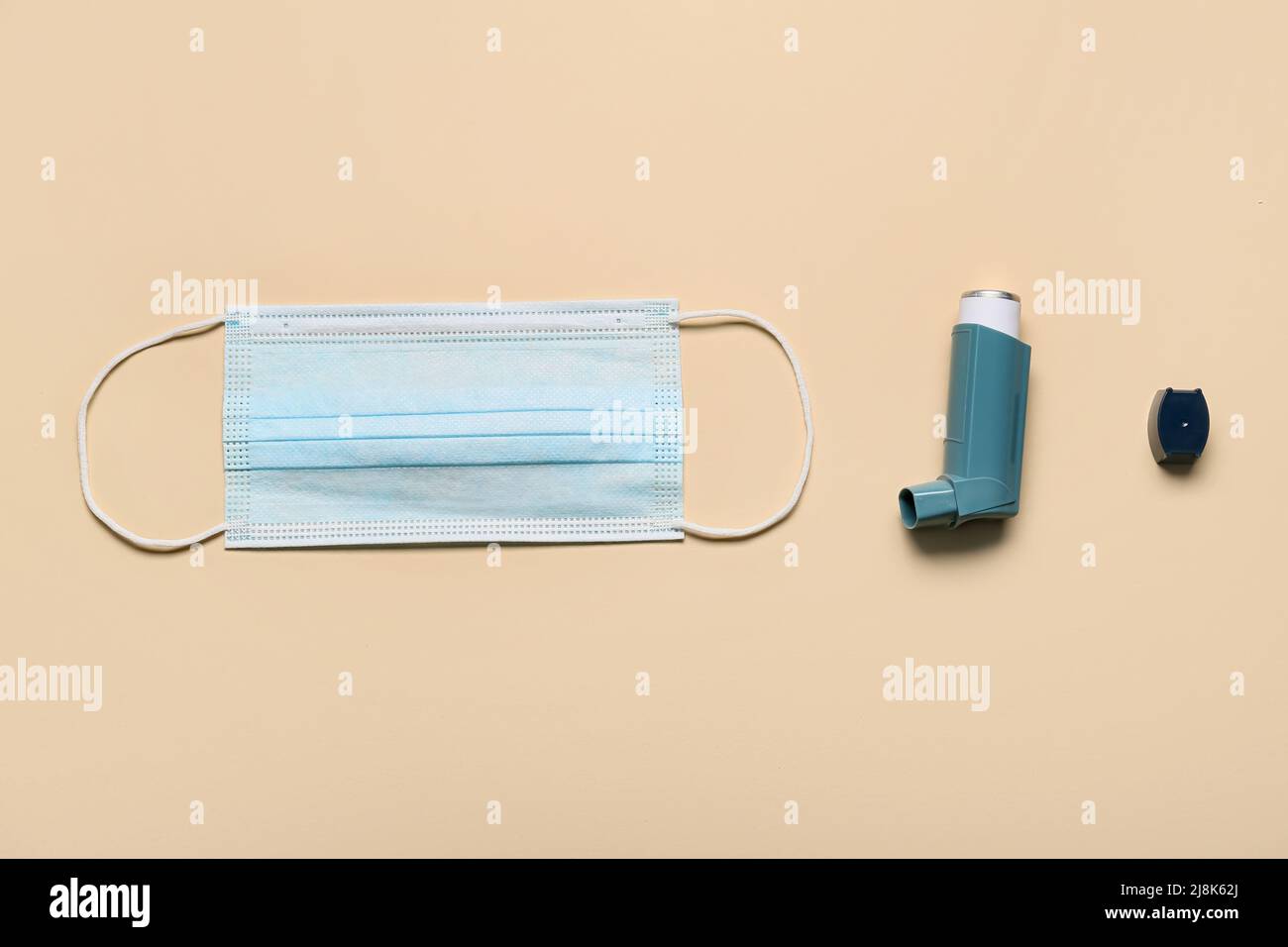 Asthma inhaler and medical mask on beige background Stock Photo - Alamy