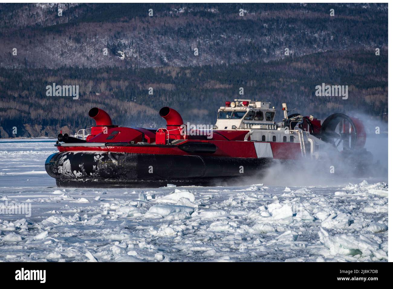 Coast Guard hovercraft breaking ice near a small community in eastern Quebec, Canada.  Stock Photo