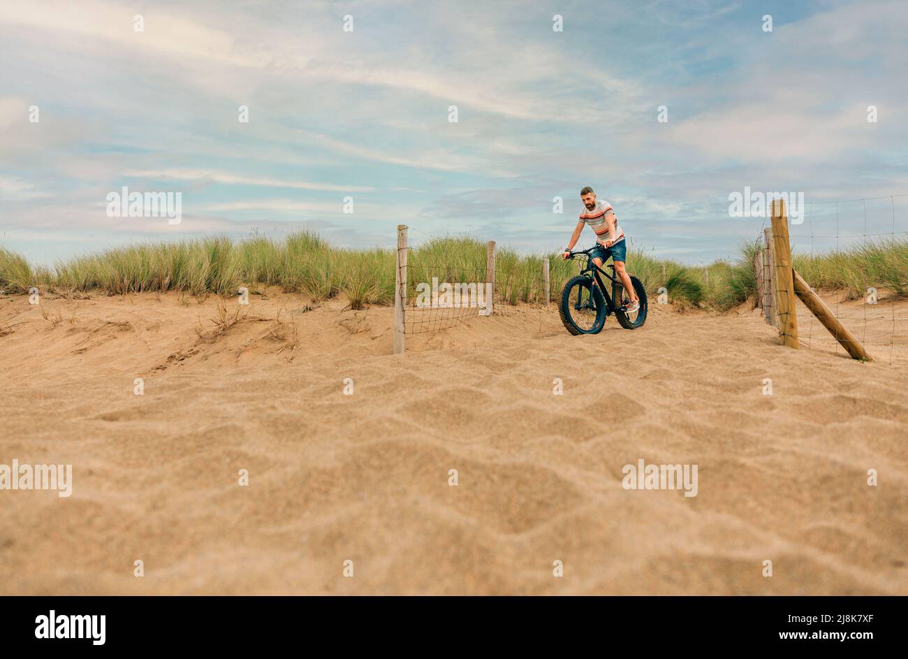 Man riding a fat bike through the beach dunes Stock Photo Alamy
