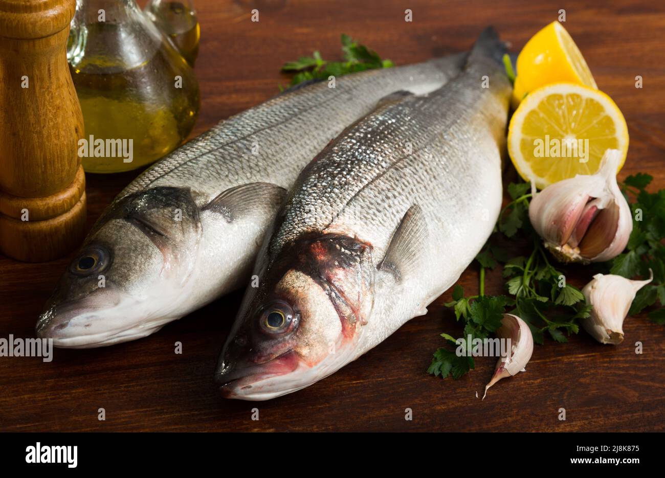 Two raw sea bass fish Stock Photo Alamy