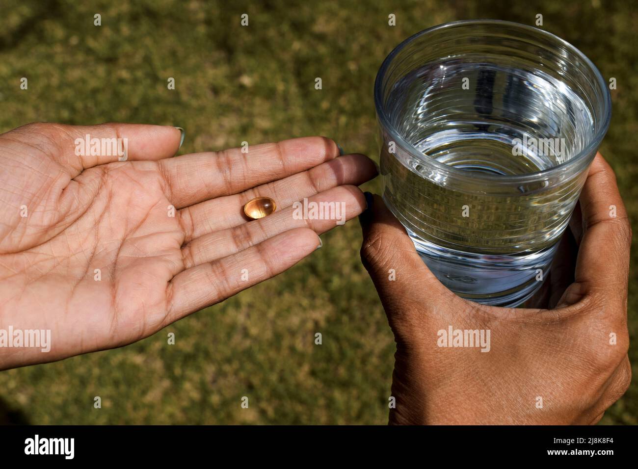 Vitamin D capsule yellow color soft shelled gel pills tablet in hand