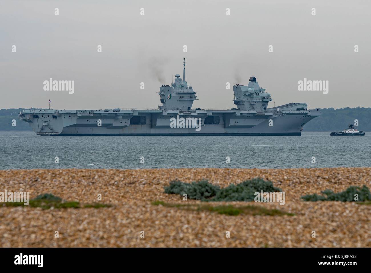 The aircraft carrier HMS Queen Elizabeth (R08) seen proceeding slowly through The Solent, UK on 15/5/2022 towards an anchorage in Stokes Bay. Stock Photo