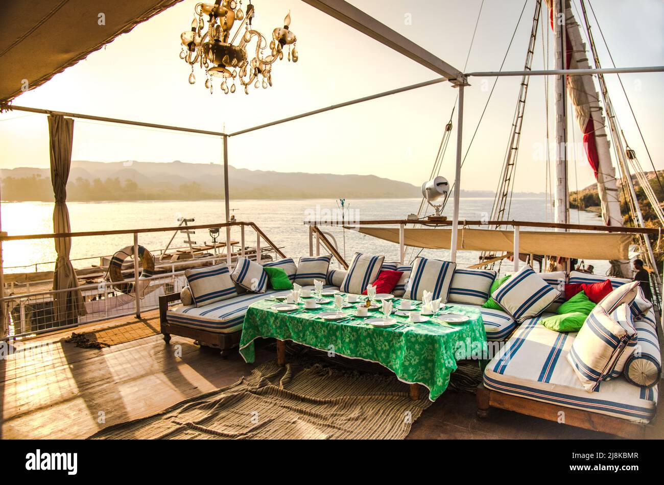 dinning area ready for breakfast on the deck of a Nile Dahabiya Tourist Boat while the boat is docked Stock Photo