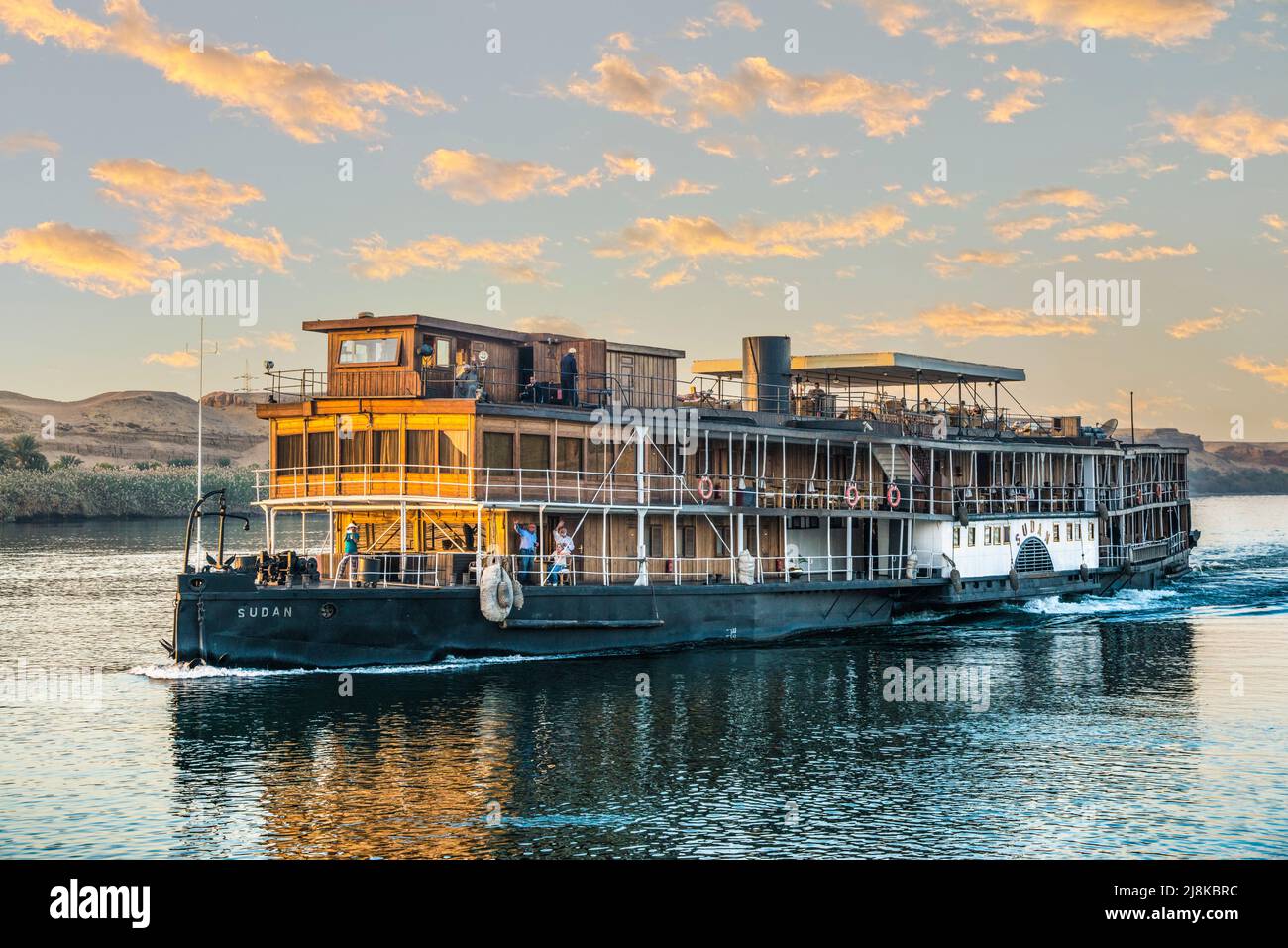 passengers wave from the Sudan paddleboat steamer on the Nile River, same boat used in the movie Death on the Nile Stock Photo