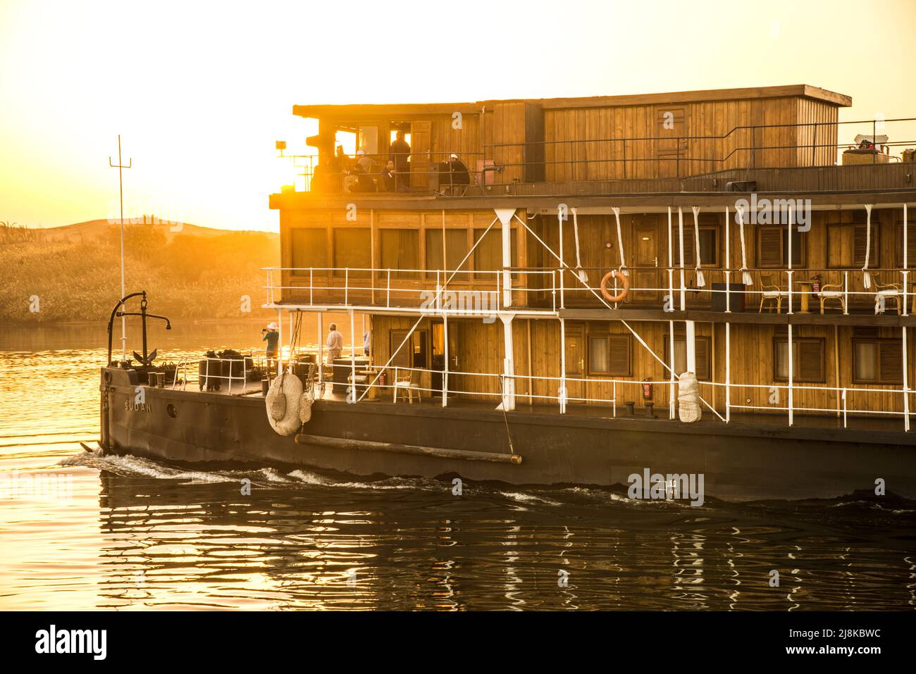 sunrise with the stern of the Sudan paddleboat steamer on the Nile River along with tourists Stock Photo