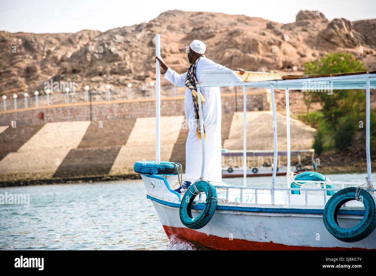 Egyptian man at the front of a ferry boat going to Agikia Island and the Philae Temple Stock Photo