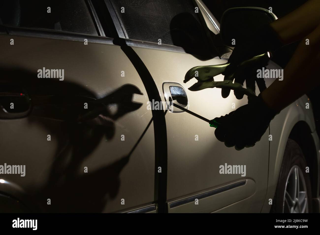 Car thief using a tool to break into a car Stock Photo Alamy