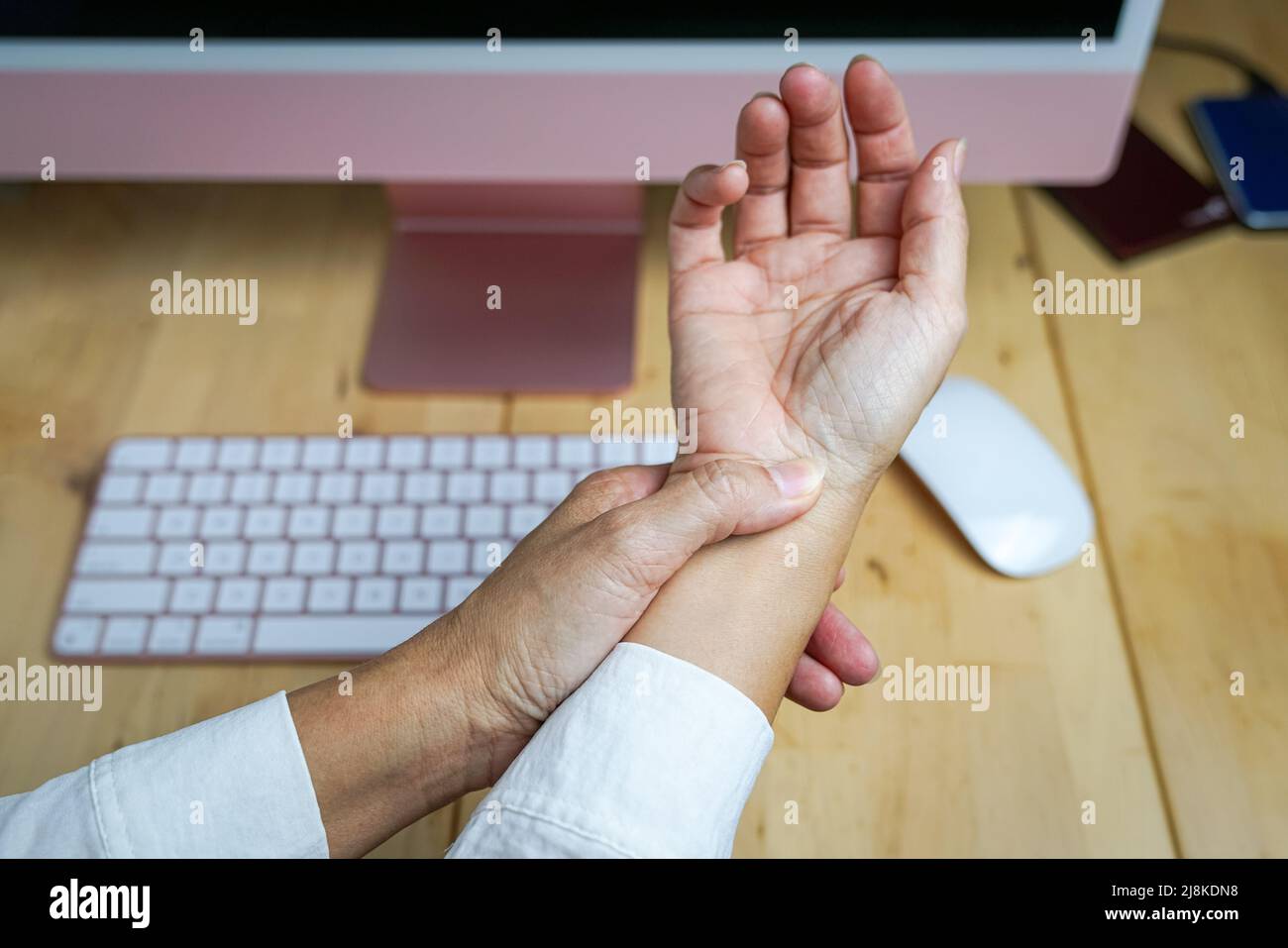 Woman rubbing her wrist, pain from using computer mouse. Carpal tunnel syndrome concept. Close