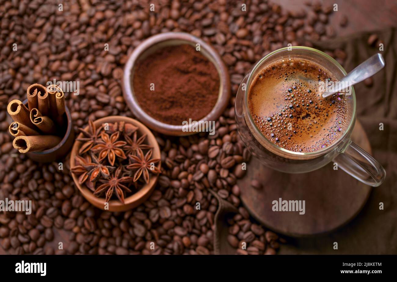 Tasty steaming espresso in cup with coffee beans. View from above. Dark background. Stock Photo